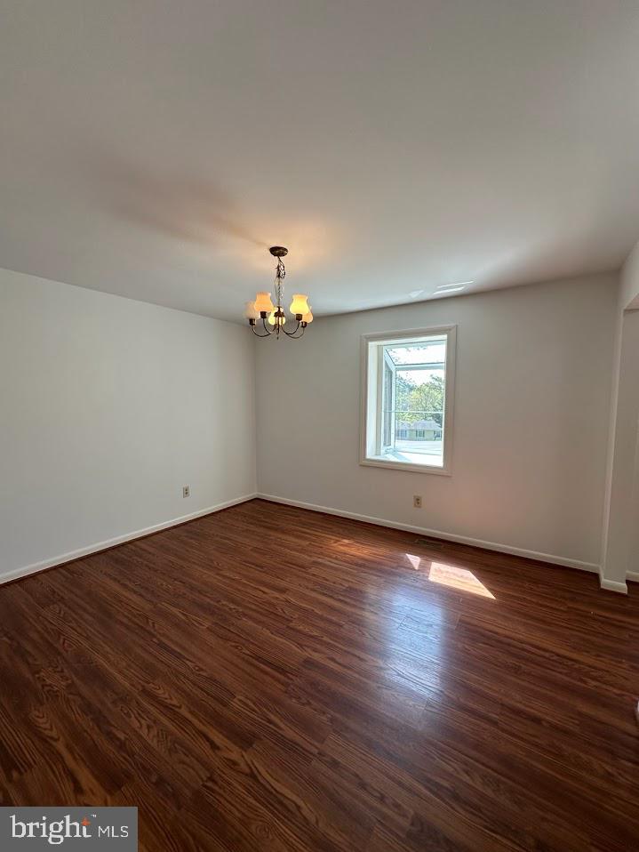 17904 Marshall Mill Road Hampstead, MD 21074 - Photo 8 of 10 an empty room with wooden floor chandelier and windows