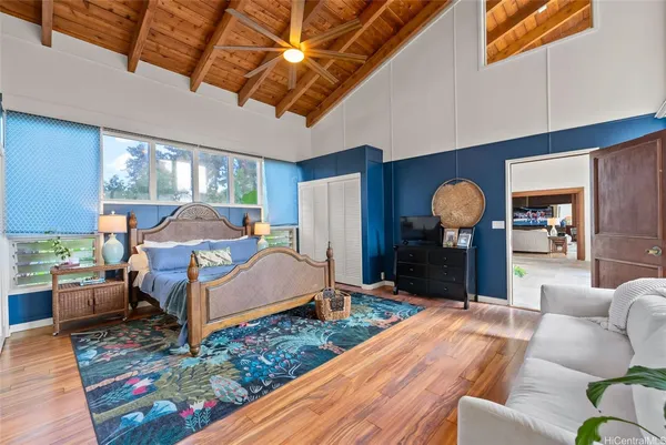 a bedroom with a bed couch and a large window