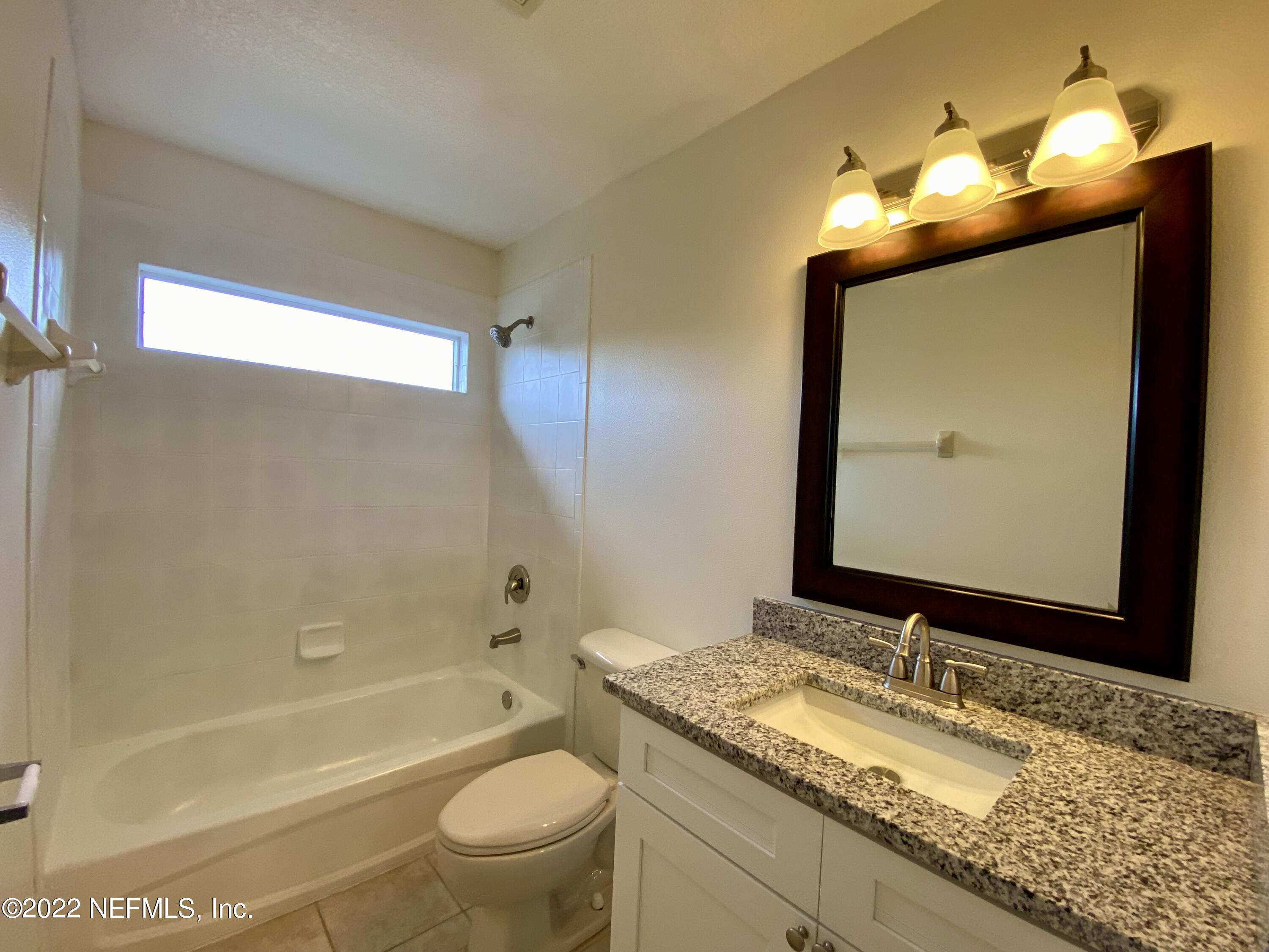 1648 Summerdown Way St. Johns, FL 32259 - Photo 11 of 14 a bathroom with a granite countertop sink toilet mirror and bathtub