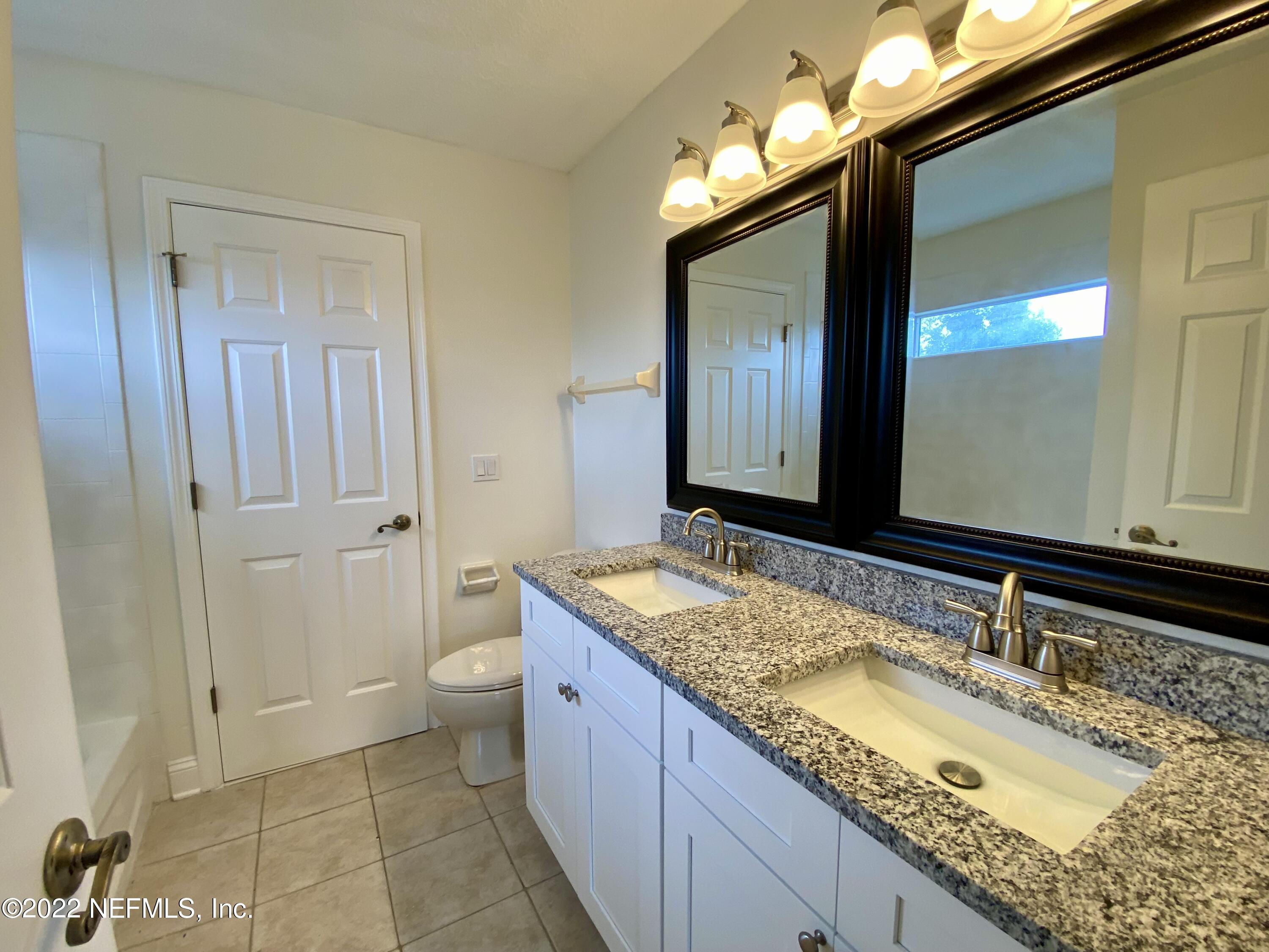 1648 Summerdown Way St. Johns, FL 32259 - Photo 13 of 14 a bathroom with a granite countertop sink a toilet and a large mirror