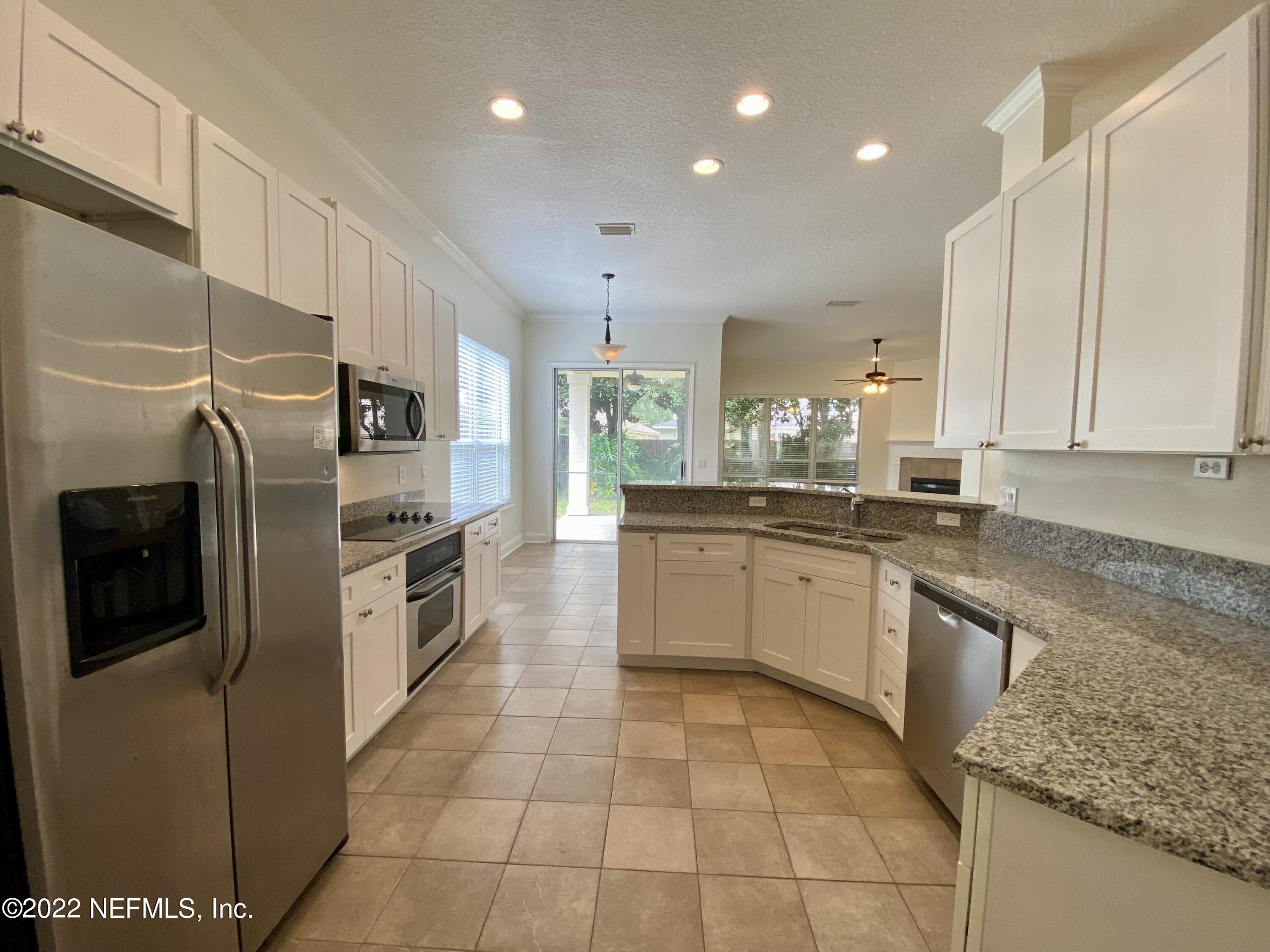 1648 Summerdown Way St. Johns, FL 32259 - Photo 4 of 14 a large kitchen with stainless steel appliances granite countertop a stove a sink and a refrigerator