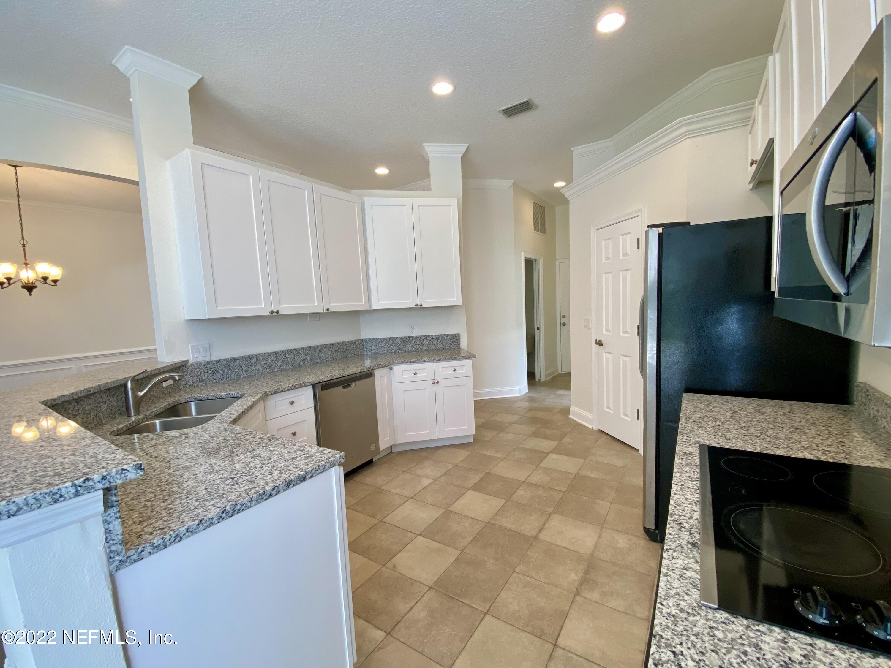 1648 Summerdown Way St. Johns, FL 32259 - Photo 5 of 14 a large kitchen with granite countertop a stove a sink and a refrigerator