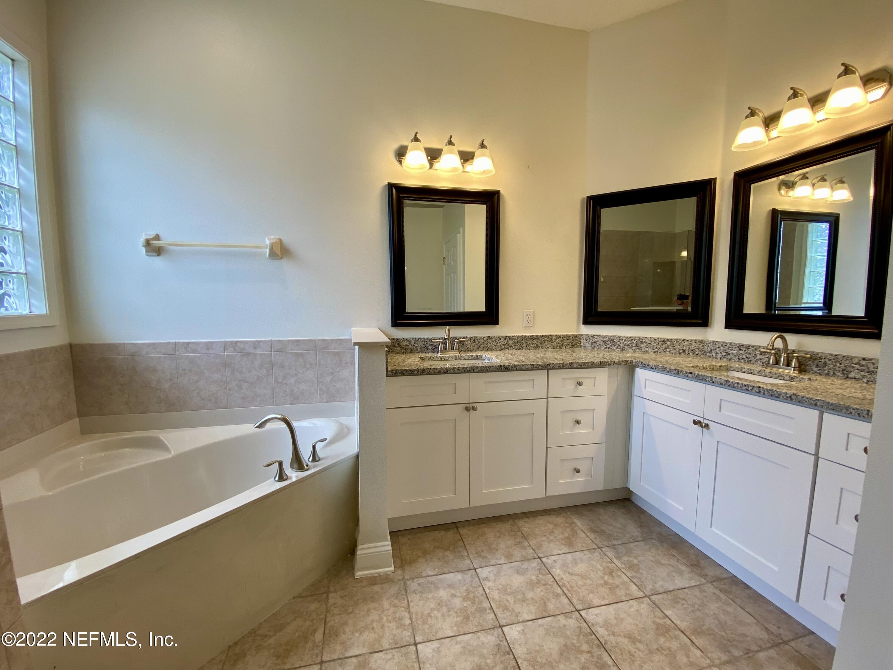 1648 Summerdown Way St. Johns, FL 32259 - Photo 8 of 14 a spacious bathroom with a granite countertop sink mirror and bathtub