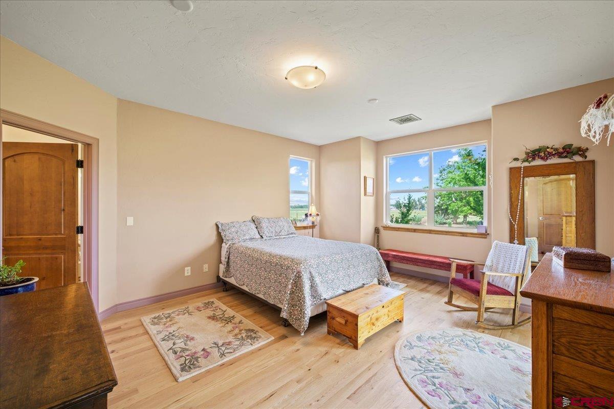 13902 5950th Road Montrose, CO 81403 - Photo 13 of 35 a bedroom with a bed and wooden floor
