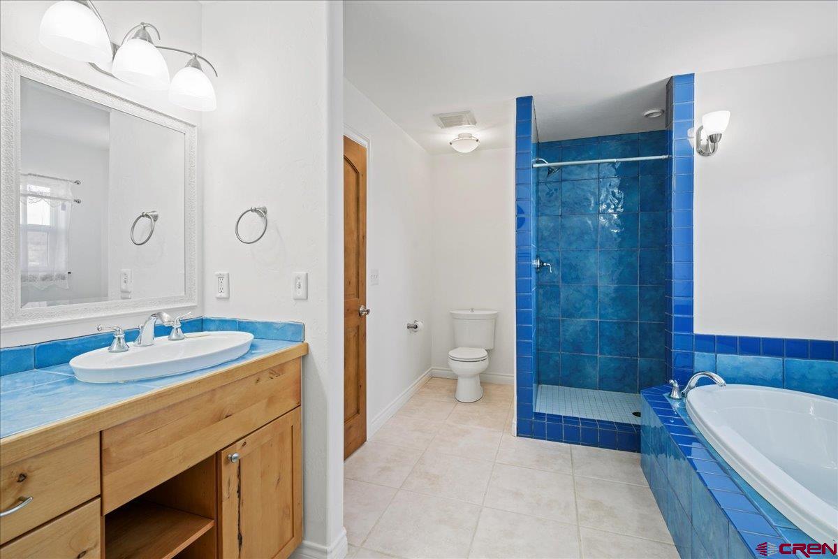 13902 5950th Road Montrose, CO 81403 - Photo 19 of 35 a bathroom with a sink a toilet a tub and shower