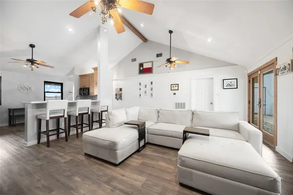 a kitchen with stainless steel appliances kitchen island granite countertop a table chairs sink and cabinets