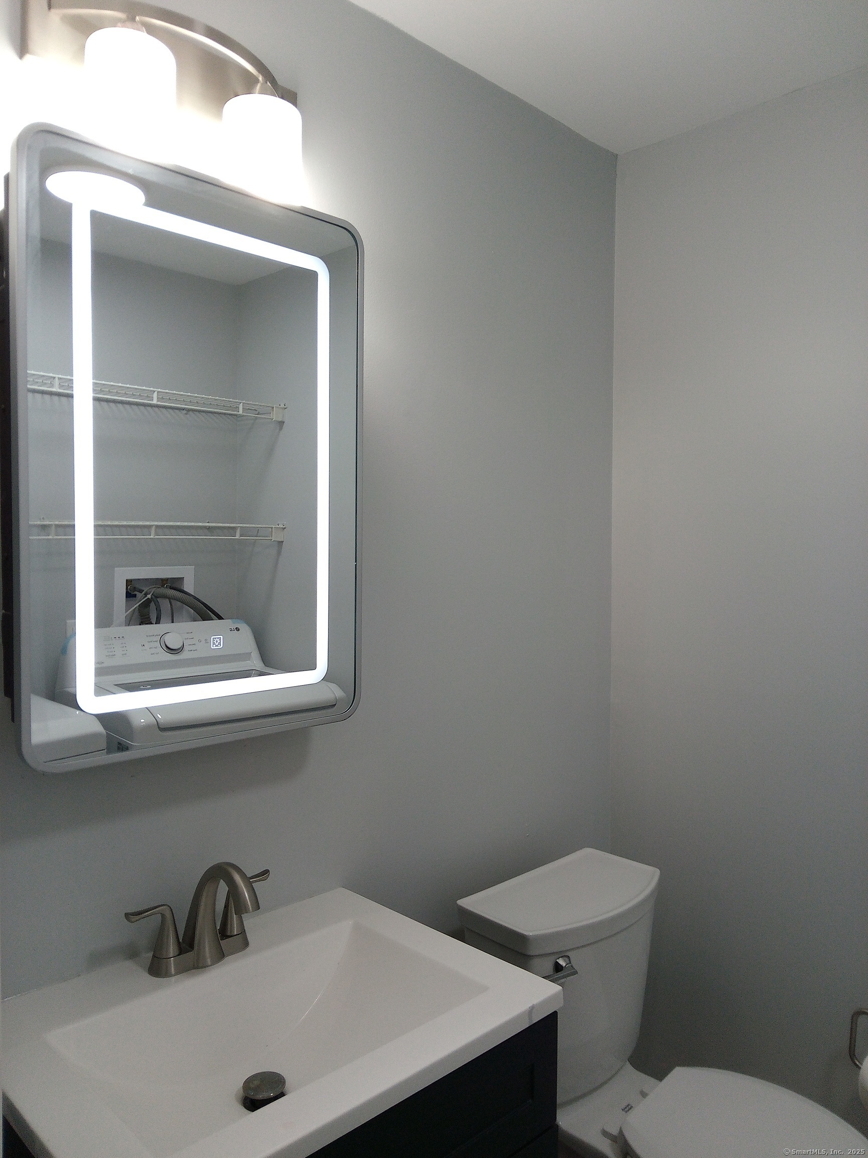 74 Washington Road, Unit 16 Woodbury, CT 06798 - Photo 14 of 25 a bathroom with a toilet sink and mirror