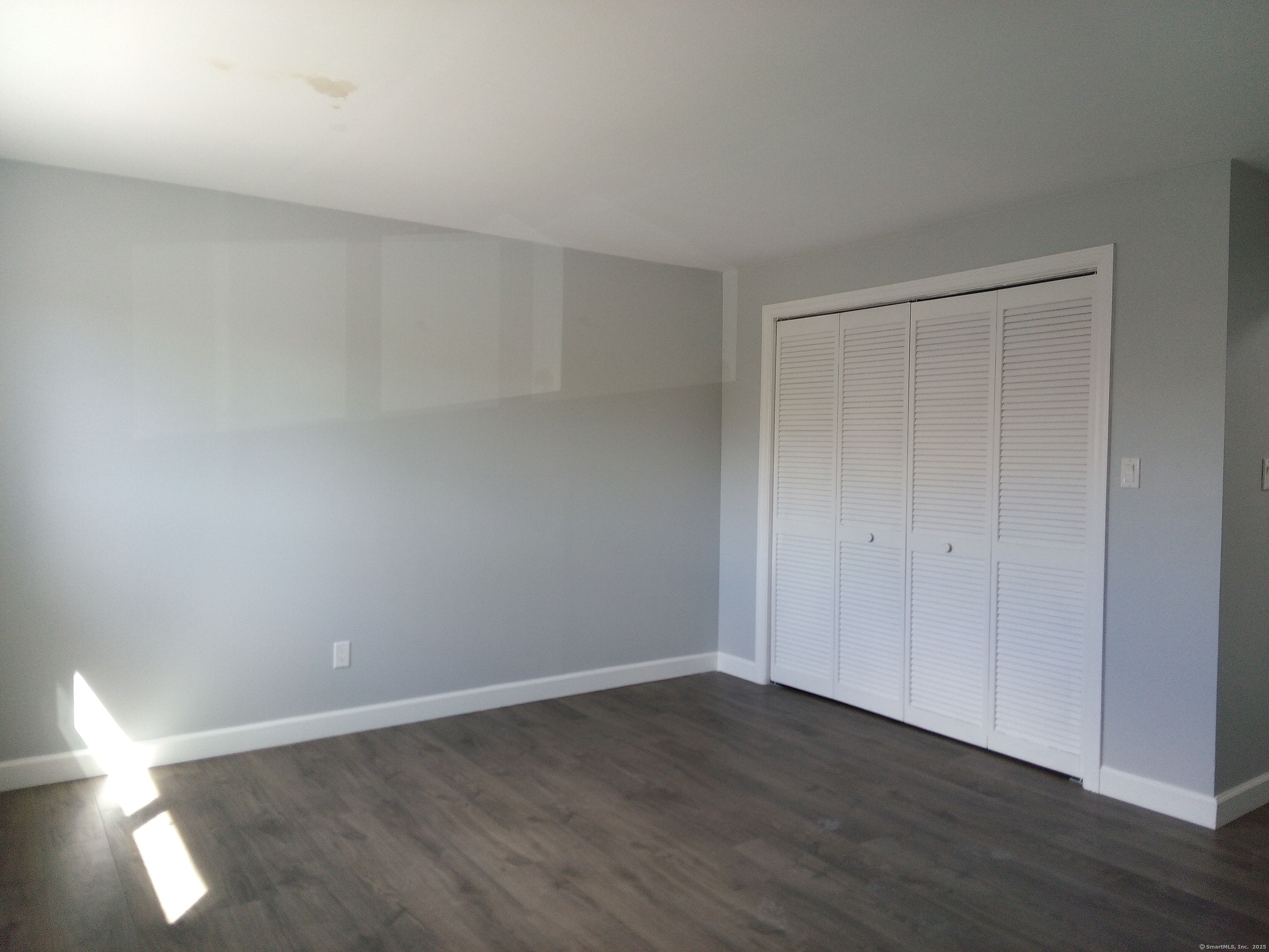 74 Washington Road, Unit 16 Woodbury, CT 06798 - Photo 18 of 25 a view of an empty room and wooden floor