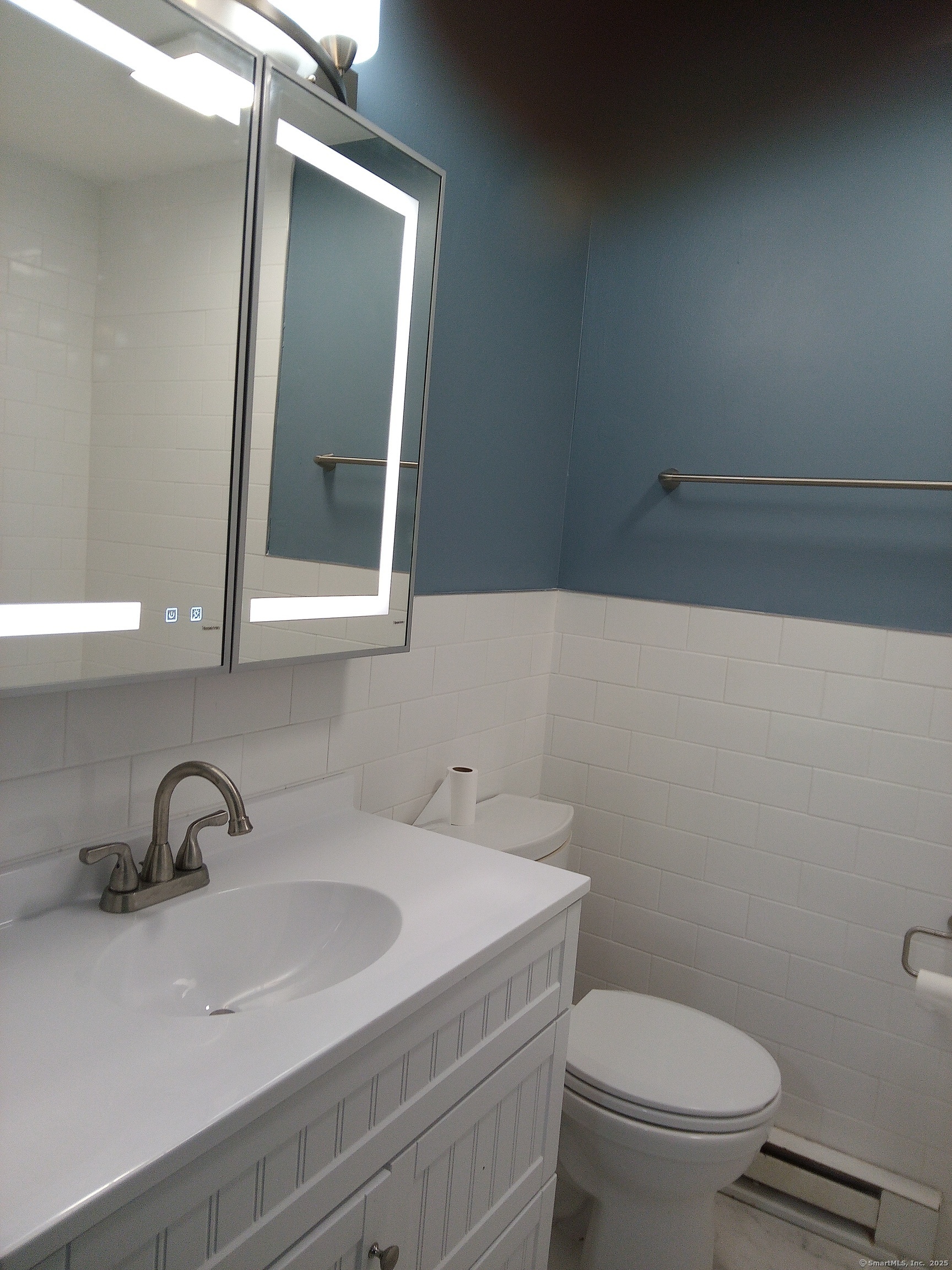 74 Washington Road, Unit 16 Woodbury, CT 06798 - Photo 20 of 25 a bathroom with a sink a toilet and mirror