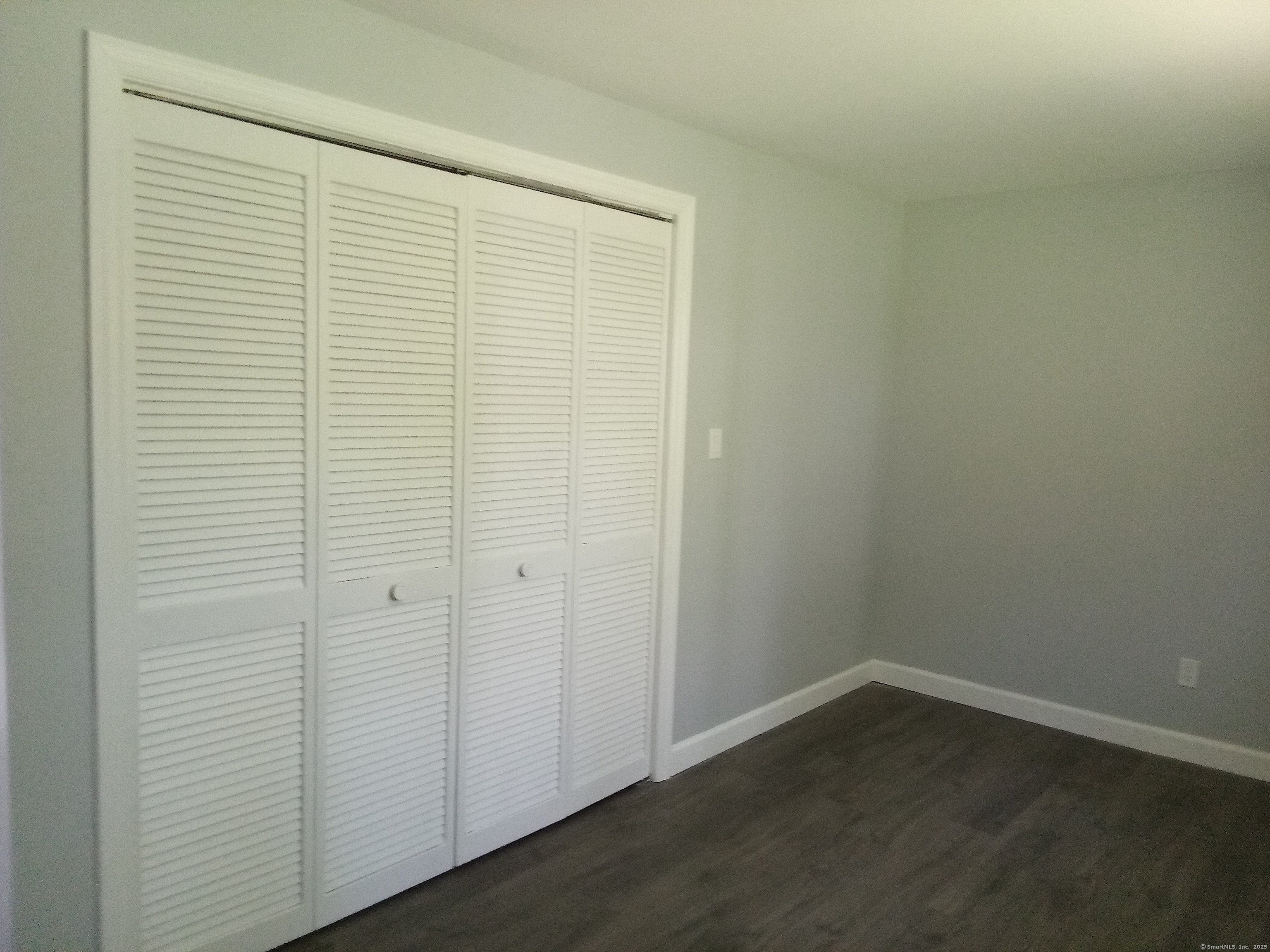 74 Washington Road, Unit 16 Woodbury, CT 06798 - Photo 23 of 25 an empty room with wooden floor