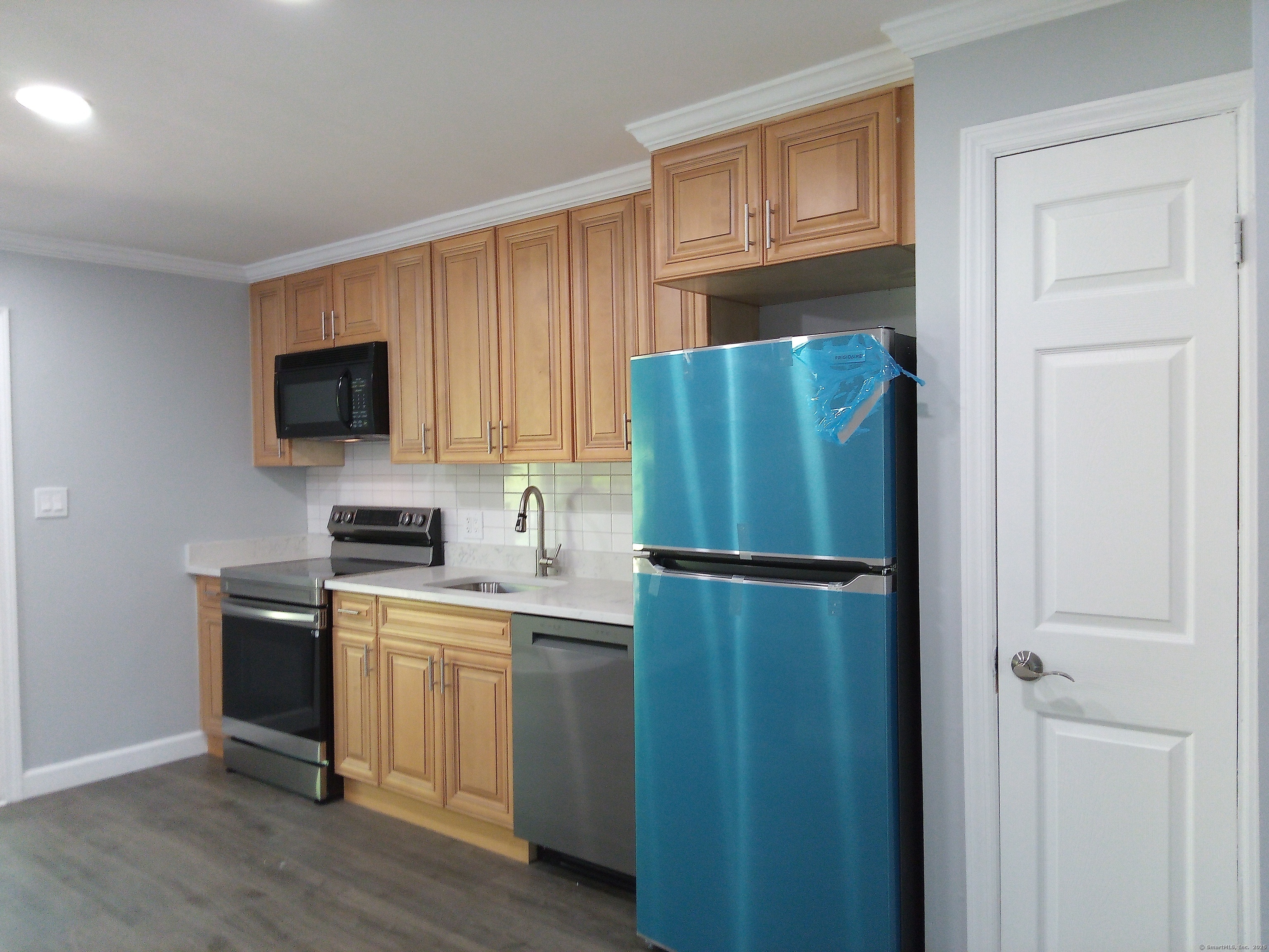 74 Washington Road, Unit 16 Woodbury, CT 06798 - Photo 10 of 25 a kitchen with a refrigerator a sink and cabinets