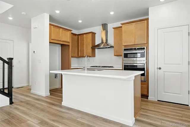 a kitchen with stainless steel appliances a refrigerator and a stove top oven