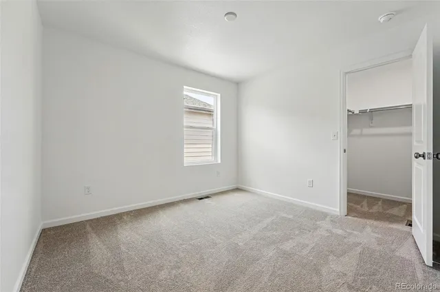 an empty room with windows and closet