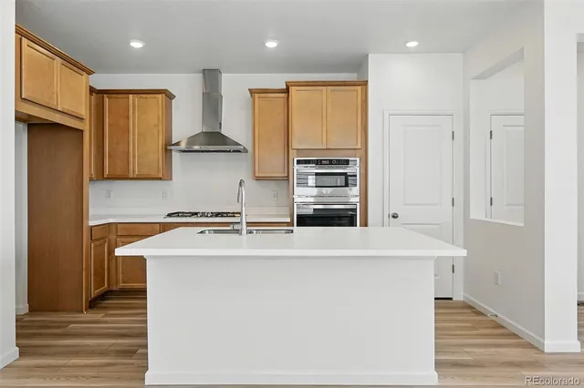 a kitchen with stainless steel appliances granite countertop a sink a stove and a refrigerator
