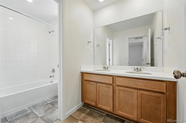 a bathroom with a tub sink and mirror