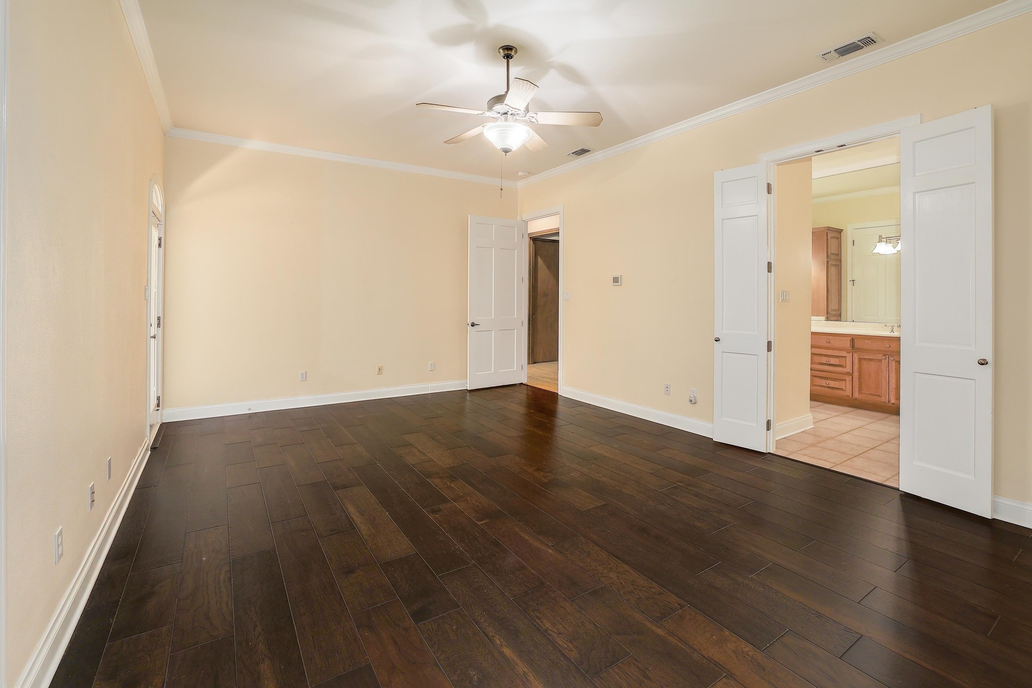 3900 Shell Road Georgetown, TX 78628 - Photo 18 of 40 Unfurnished bedroom featuring crown molding, dark wood finished floors, a ceiling fan, and ensuite bathroom