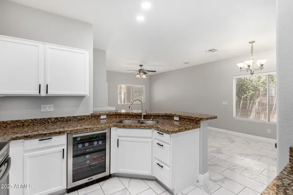 a kitchen with granite countertop a sink stainless steel appliances and cabinets
