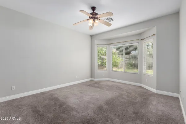 a view of a room with windows and a chandelier fan