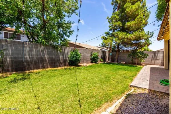 a view of a backyard with table and chairs and wooden fence