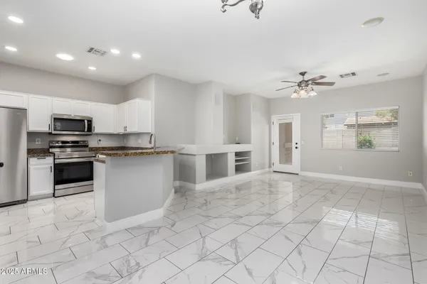 a kitchen with stainless steel appliances kitchen island granite countertop a sink and cabinets