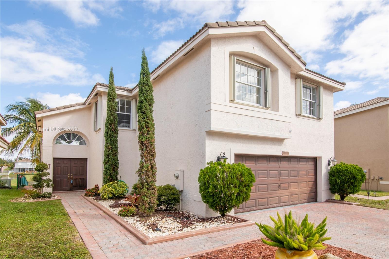 14821 Southwest 20th Street Miramar, FL 33027 - Photo 1 of 50 a front view of a house with garden