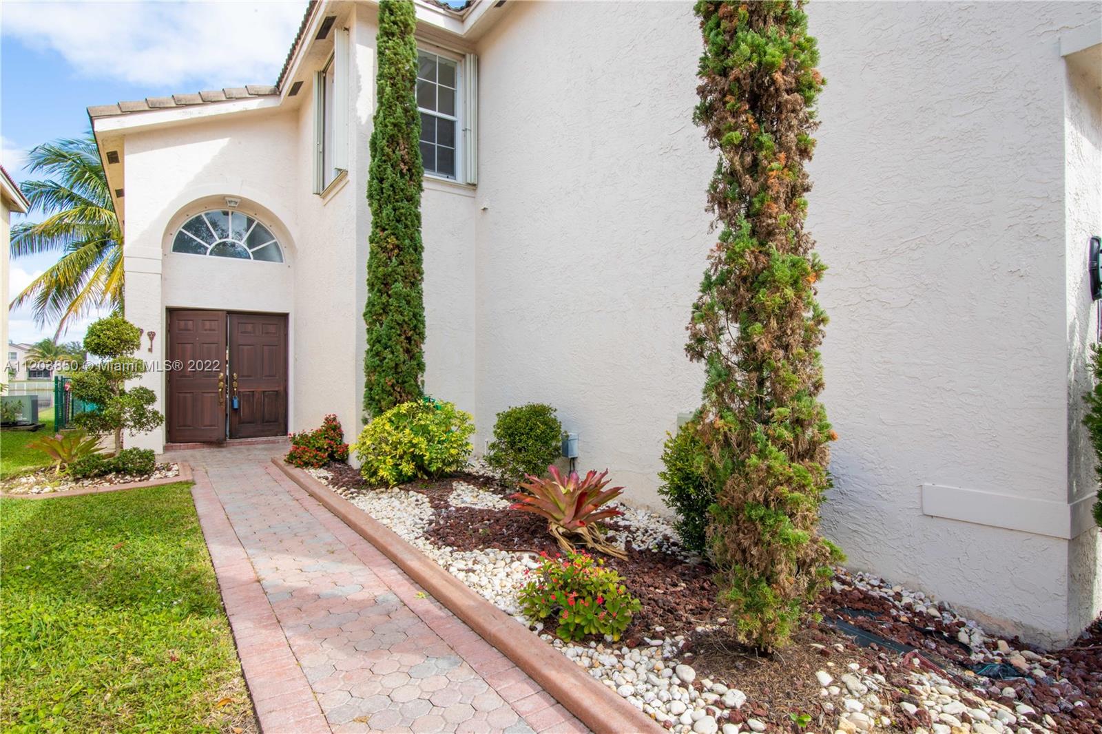 14821 Southwest 20th Street Miramar, FL 33027 - Photo 11 of 50 a front view of a house with a yard and flowers