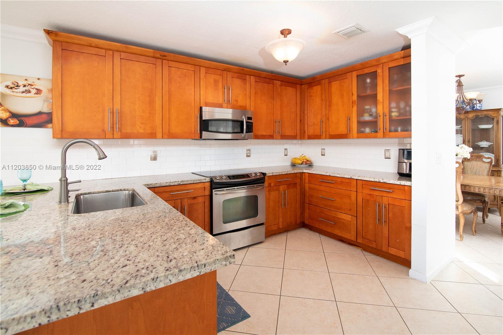 14821 Southwest 20th Street Miramar, FL 33027 - Photo 17 of 50 a kitchen with stainless steel appliances granite countertop a sink stove and refrigerator