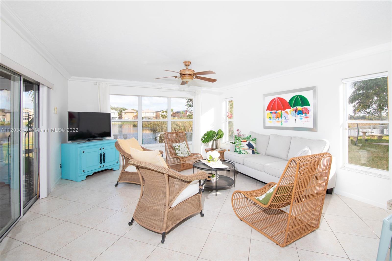 14821 Southwest 20th Street Miramar, FL 33027 - Photo 18 of 50 a living room with furniture a flat screen tv and a table