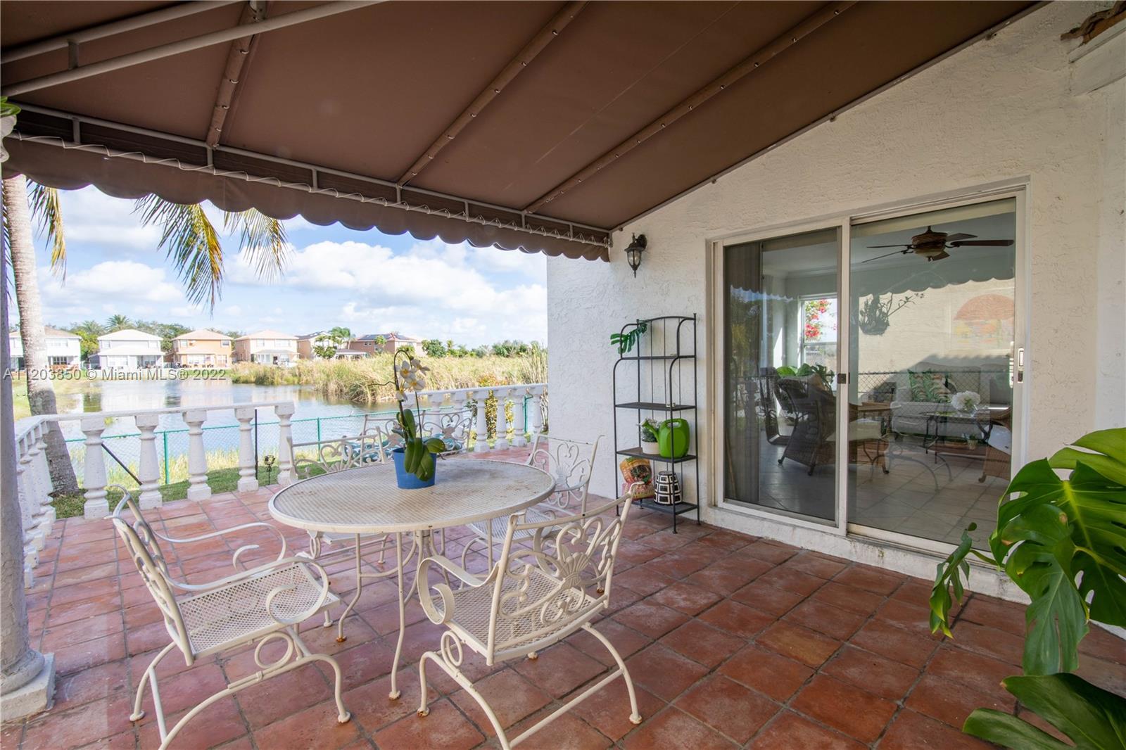 14821 Southwest 20th Street Miramar, FL 33027 - Photo 21 of 50 a view of a patio with a table and chairs under an umbrella
