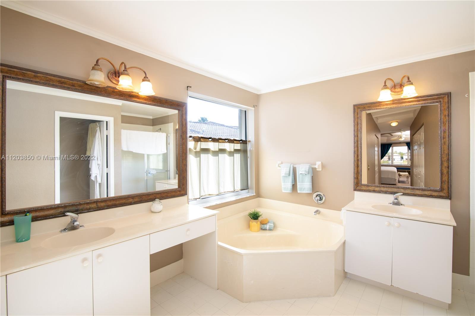 14821 Southwest 20th Street Miramar, FL 33027 - Photo 7 of 50 a bathroom with a sink a large mirror and a bathtub