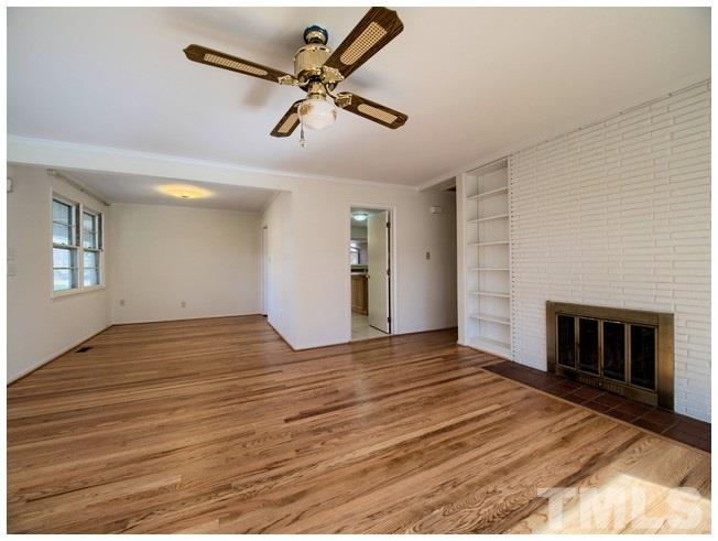 3309 Leonard Street Raleigh, NC 27607 - Photo 6 of 21 a view of empty room with wooden floor and fireplace