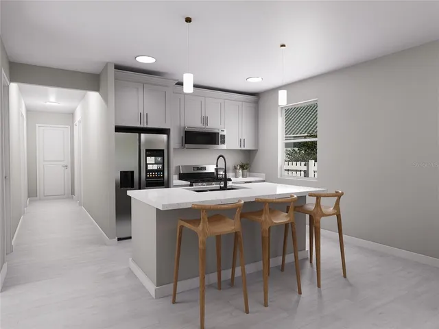 a kitchen with kitchen island a stove a sink a refrigerator and a refrigerator