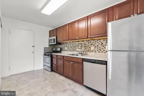 a kitchen with stainless steel appliances granite countertop a refrigerator and a sink
