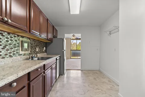 a kitchen with granite countertop stainless steel appliances a sink and cabinets