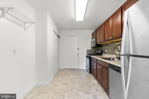a kitchen with granite countertop a refrigerator stove top oven and sink