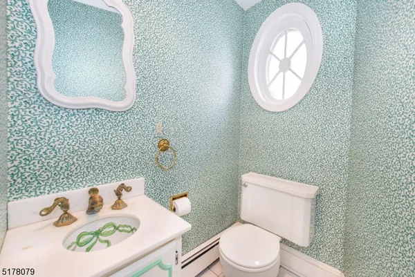 a bathroom with a toilet sink vanity and mirror