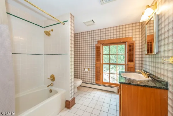 a bathroom with a granite countertop sink a bathtub and a shower