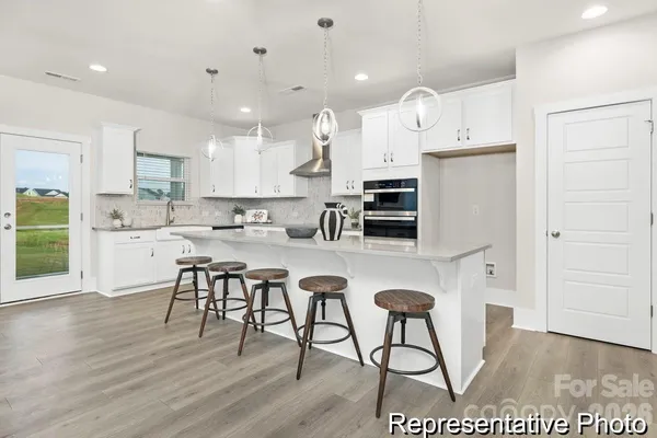 a kitchen with stainless steel appliances kitchen island granite countertop a stove a sink a refrigerator and a cabinets