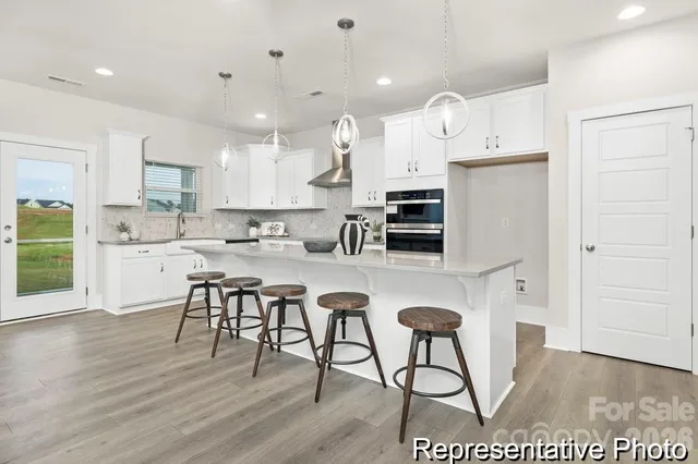 a kitchen with stainless steel appliances kitchen island granite countertop a stove a sink a refrigerator and a cabinets