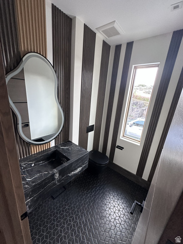 1918 Chimney Rock Road Heber City, UT 84032 - Photo 33 of 74 Powder room featuring a floating black marble vanity with an integrated sink, a contemporary illuminated mirror, and a wall-mounted black toilet