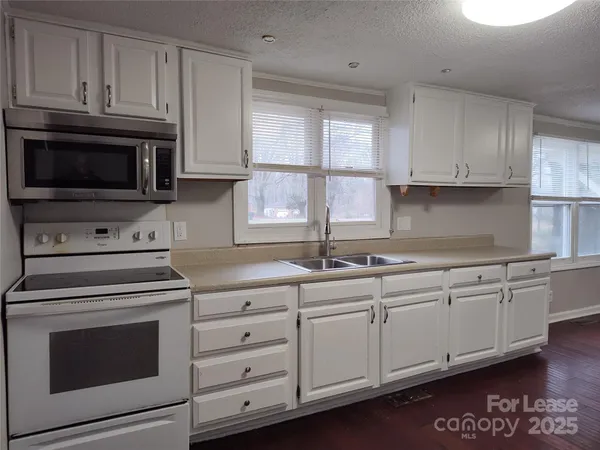 a kitchen with granite countertop cabinets stainless steel appliances and a window