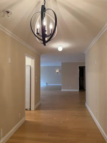 a view of a livingroom with a mirror and wooden floor