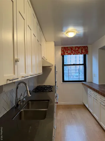 a kitchen with stainless steel appliances a sink stove and cabinets