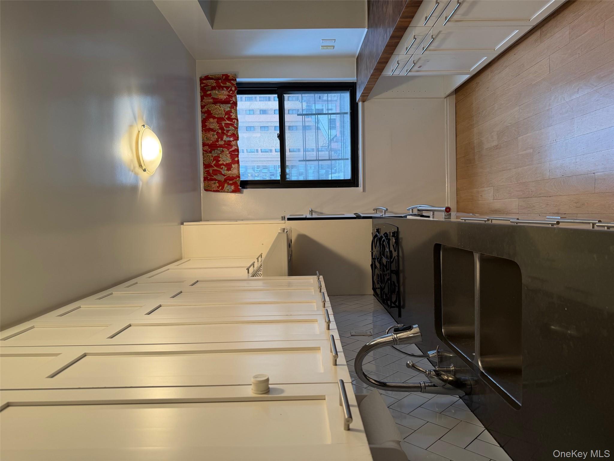 420 East 51st Street, Unit 8DE Manhattan, NY 10022 - Photo 14 of 17 a kitchen with stainless steel appliances a sink stove and cabinets