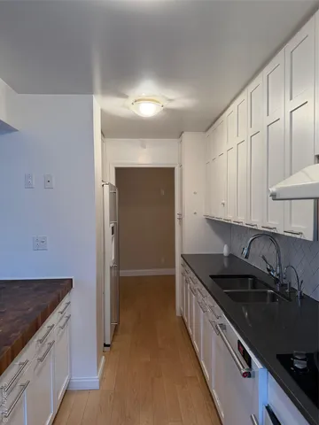 a kitchen with granite countertop a sink and a stove top oven