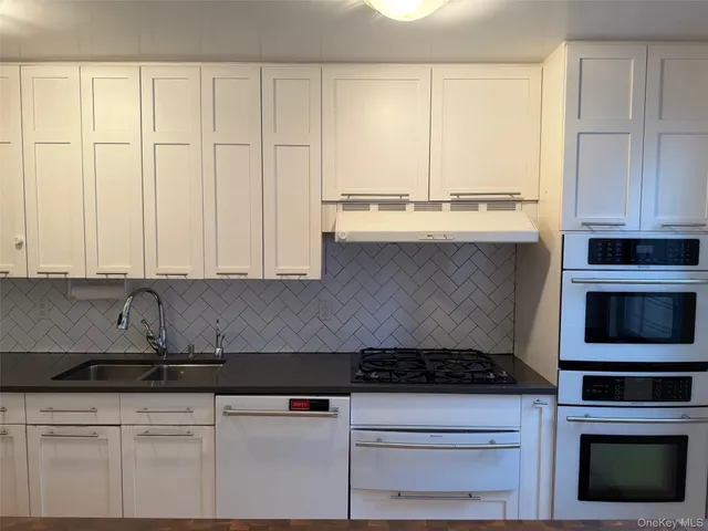 a kitchen with granite countertop a stove sink and cabinets