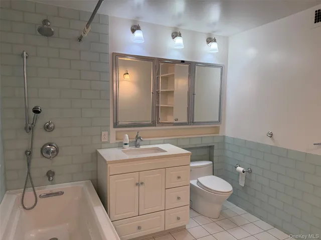 a bathroom with a toilet sink shower and mirror