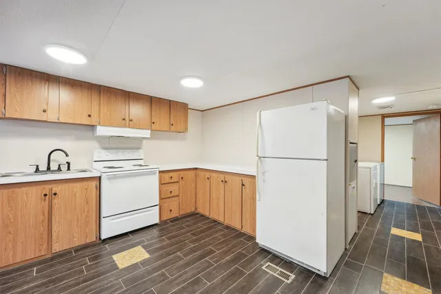 a kitchen with wooden cabinets and white appliances