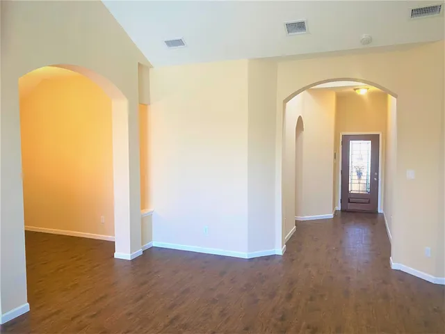an empty room with wooden floor and closet