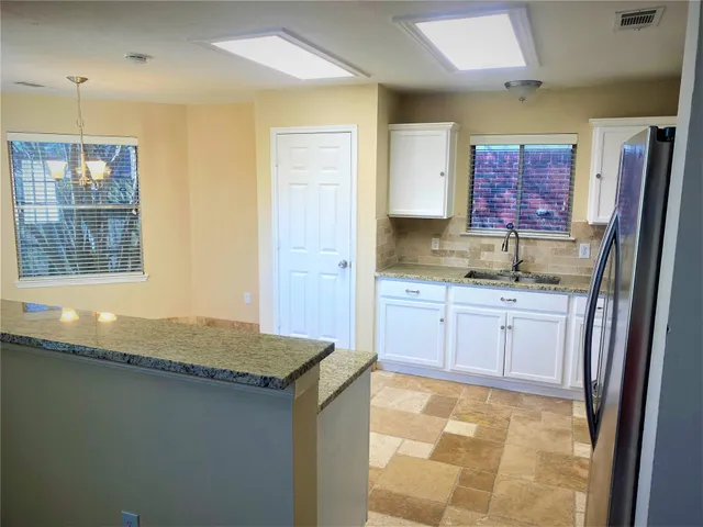 a kitchen with granite countertop a sink stove and cabinets
